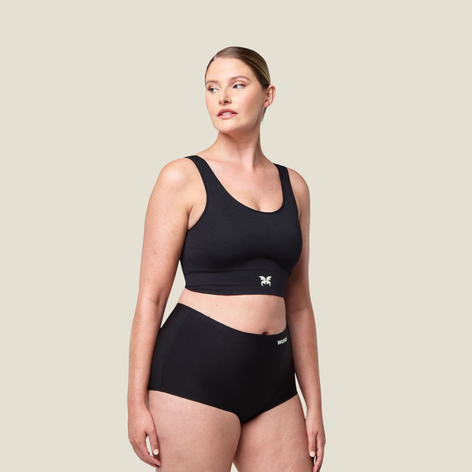 Woman wearing WUKA Stretch™ Boxer Period Pants in black, full-length front view, designed for heavy flow and offering a comfortable, seamless fit.