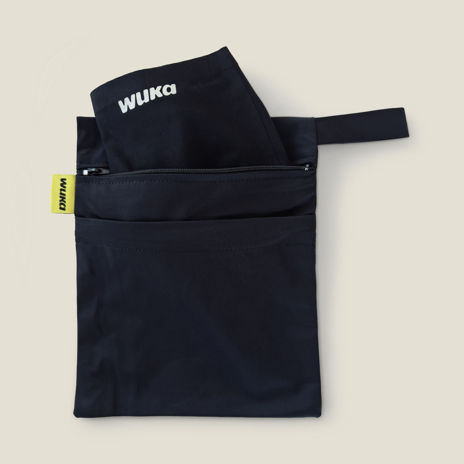 WUKA Two Pocket Changing Bag with black WUKA pants tucked inside the main zip pocket, showcasing compact and discreet storage for on-the-go period changes.