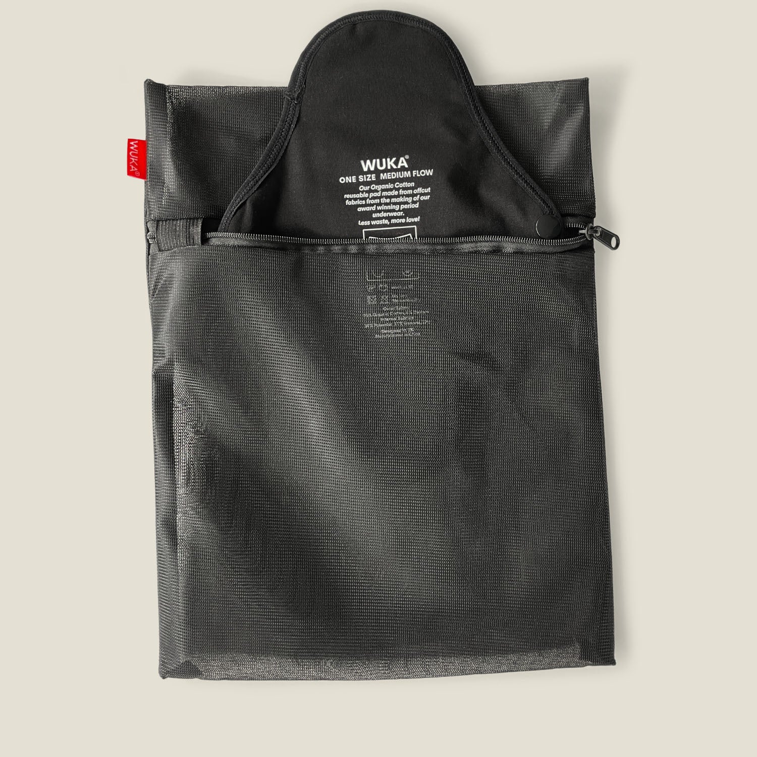 Open WUKA mesh laundry bag with reusable period pads partially visible, designed to protect items during washing.