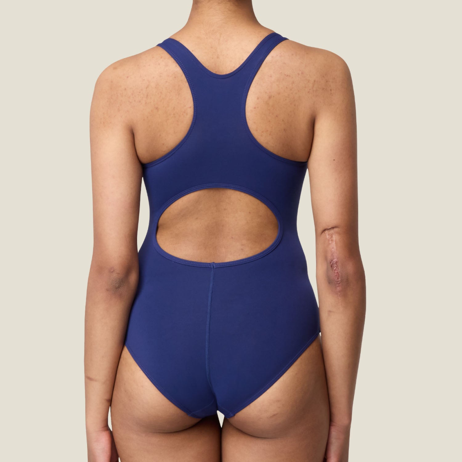 Back view of WUKA navy racerback period swimsuit showing open back cut and racerback straps, designed for leak-free confidence.