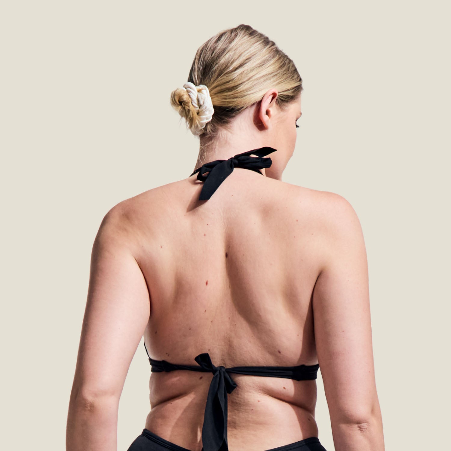 Back view of WUKA black swim bikini top, showcasing adjustable neck and back ties for a secure fit.